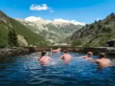 People soaking in Andorran natural thermal waters, surrounded by stunning mountain views.