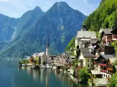 Austrian lakeside village with tall green mountains in the background.