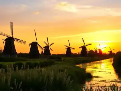 Kinderdijk windmills at sunset with reflections in water.