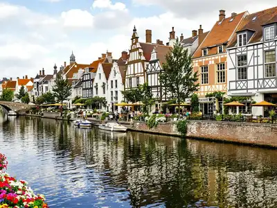 Canals of Bruges with medieval architecture and flowers.