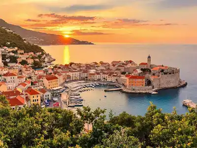 Beautiful Dubrovnik coastline with historic buildings and sunset.