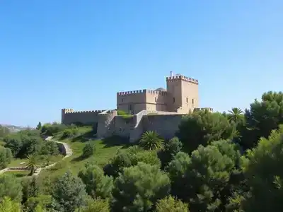 Kolossi Castle surrounded by greenery and blue sky.