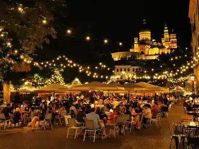 Couples enjoying outdoor cafés under warm night lights.