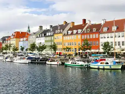 Copenhagen waterfront with boats and colorful buildings.