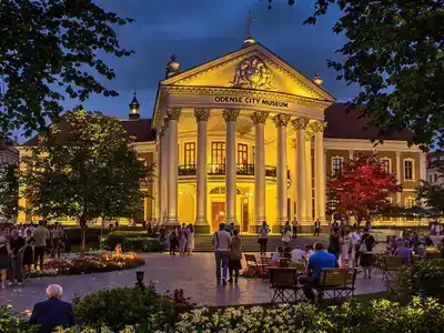 Evening view of Odense City Museum with visitors.