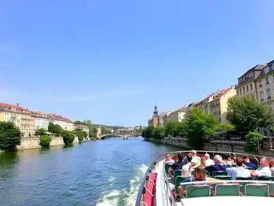 Scenic river cruise with historic buildings and greenery.