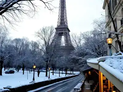 Eiffel Tower in winter with snow and Parisian streets.