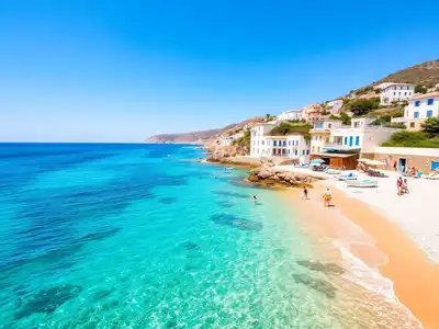 Beautiful Greek beach with turquoise waters and white buildings.