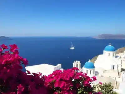 Aerial view of Santorini’s white buildings and blue sea.