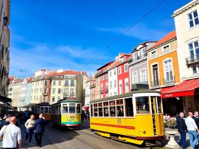 Colorful Lisbon street scene with tram and cafés.