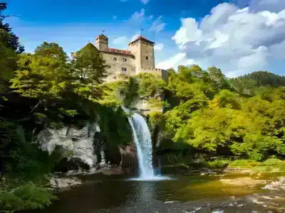 Niedzica Waterfall and castle with a blue cloudy sky