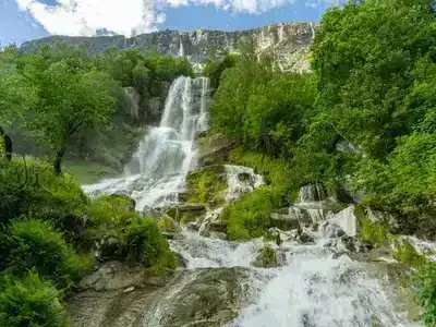 The white water Vinnufossen waterfall flowing through lush greren trees