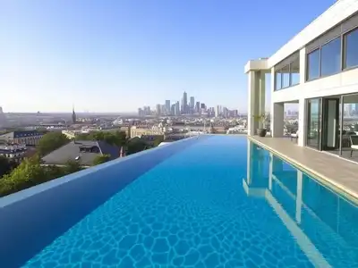 Infinity pool with urban skyline and lush greenery.