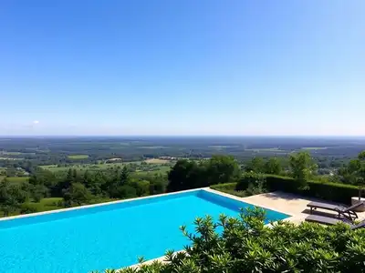 Infinity pool with scenic French countryside view.