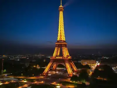 Eiffel Tower lit up at night in Paris.