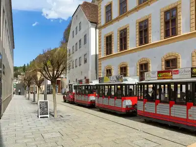 The Citytrain Ride in Vaduz showing the red and white carriages being pulled along a street