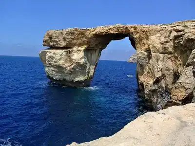 Scenic view of Malta's coastline with a stone arch.