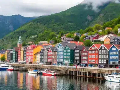 Colorful wooden houses in Bergen with green mountains.