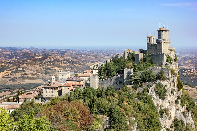 The three towers of San Marino atop a hill with a clear blue sky