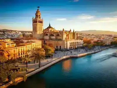 Giralda Spain, showing a tower and people walking by the riverside