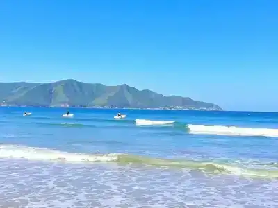 Surfers enjoying gentle waves at Somo beach.