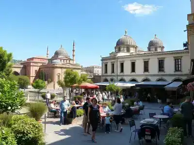 Istanbul courtyard with outdoor dining, historic domes, lush scenic view.